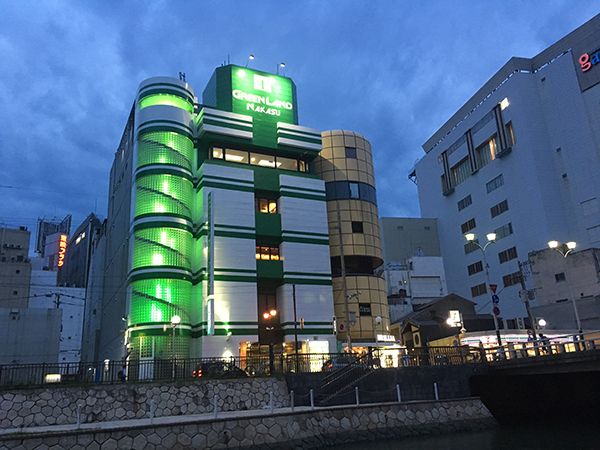 Greenland Nakasu - Male Only in Fukuoka, neon-lit hotel exterior at dusk with green tower lights