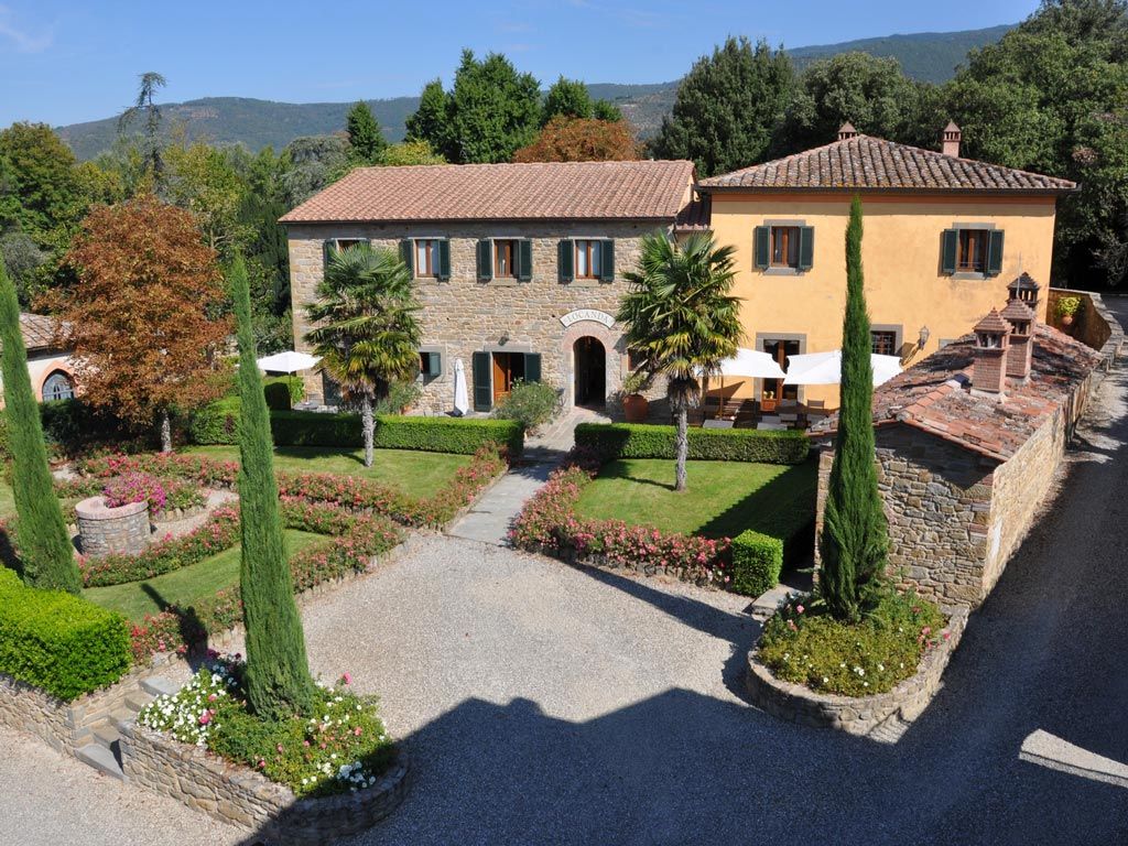 Borgo iI Melone in Cortona with a landscaped courtyard, stone villas, and mountain views
