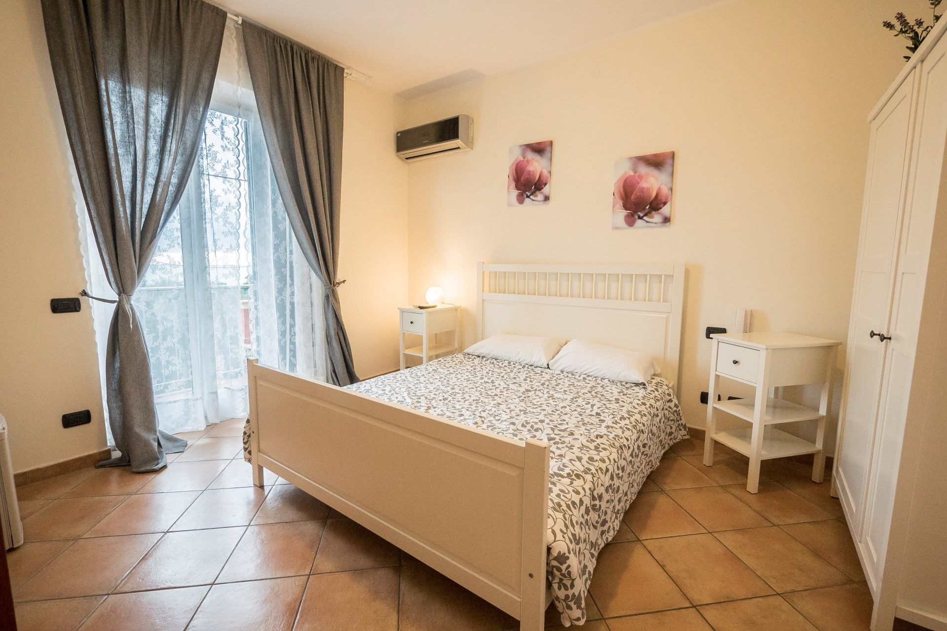 Gambero Nero in Tellaro bedroom with double bed, balcony doors and tiled floor