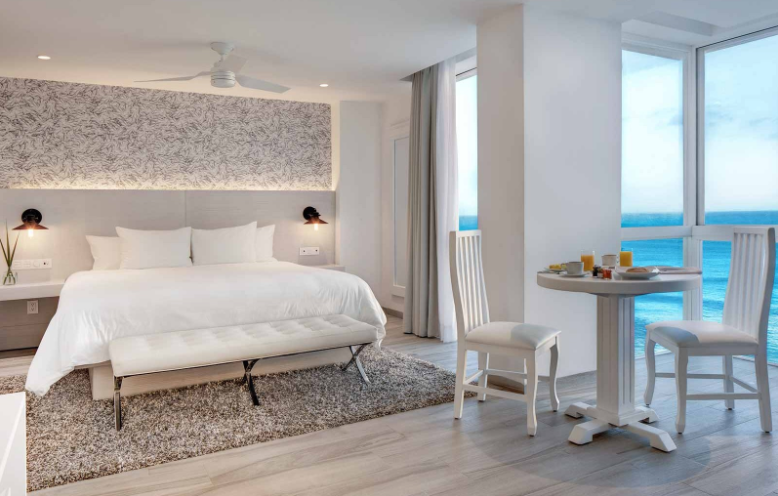 Oleo Cancun Playa in Cancún, beachfront guest room with ocean view, white bed and dining table