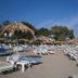 Theodorou Beach Hotel Apartments in Kos: sandy beach with lounge chairs and straw umbrellas