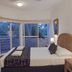 Beach Terraces in Port Douglas bedroom with king bed, wicker headboard, and balcony doors