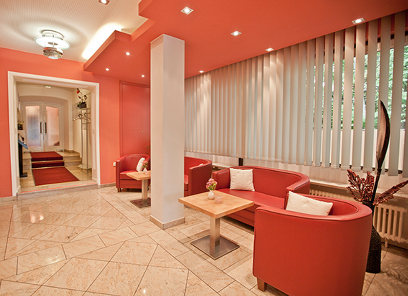 Würmtaler Gästehaus in Graefelfing lobby with coral seating, tiled floor and large vertical blinds
