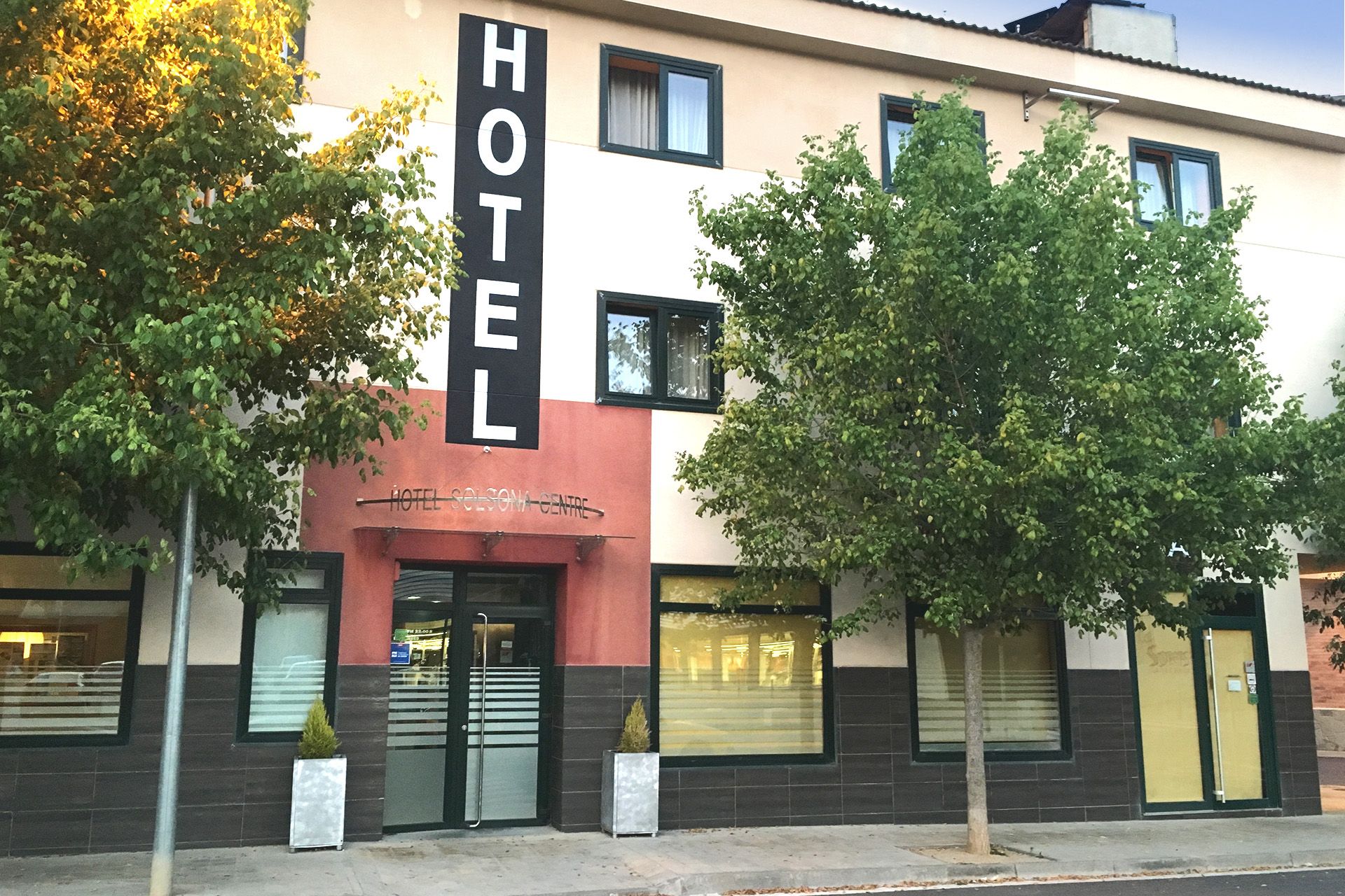 Hotel Solsona Centre in Solsona, street-facing hotel exterior with trees and vertical HOTEL sign