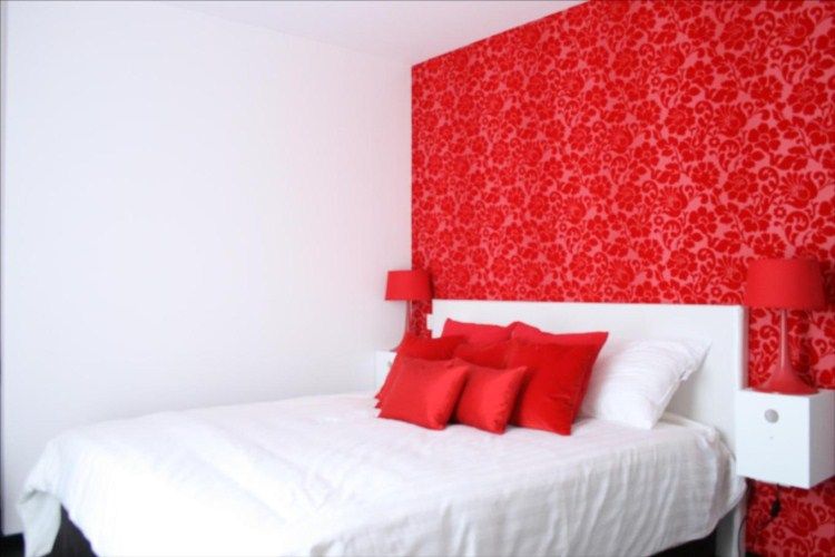 Hotel Esperance Brussels guest room with white bed, red pillows, and bold red floral accent wall