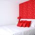 Hotel Esperance Brussels guest room with white bed, red pillows, and bold red floral accent wall