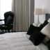 Hotel Esperance Brussels guest room with bed, black chair, bedside lamp and curtains