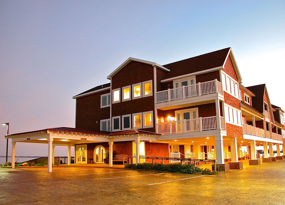 Oasis Suites Hotel in Nags Head, exterior with balconies and covered entrance at sunset