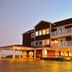 Oasis Suites Hotel in Nags Head, exterior with balconies and covered entrance at sunset