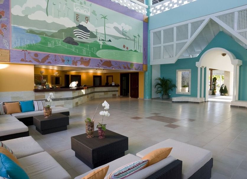 Grand Paradise Playa Dorada lobby in Puerto Plata with colorful mural, seating area and open reception