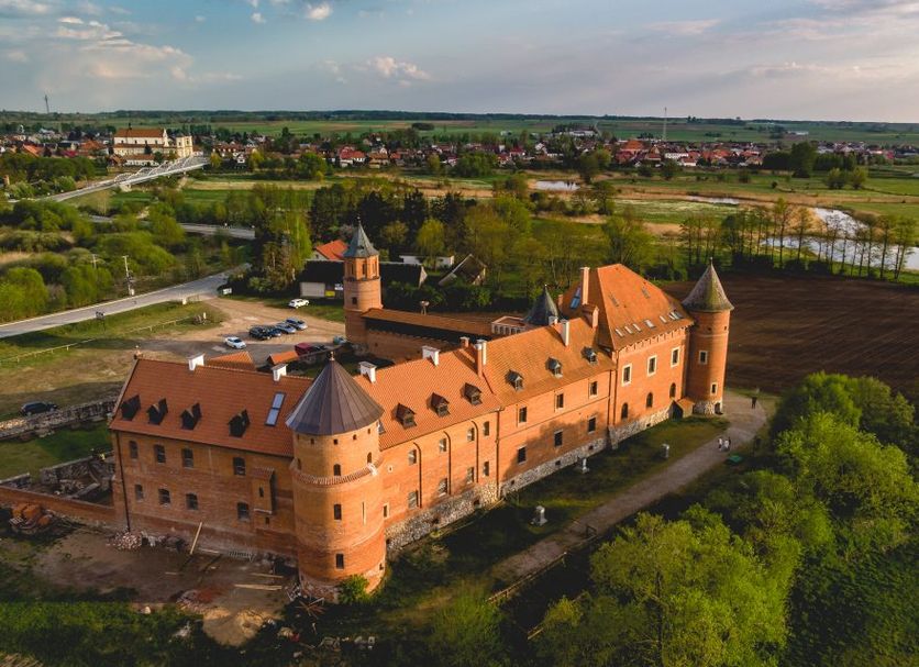 Zamek w Tykocinie in Tykocin, aerial view of a historic castle with orange roofs and surrounding greenery