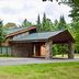 Whitetail Lodge in Saint Germain with stone lodge entrance, covered driveway, and pine trees