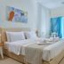 Vasia Ormos Hotel room in Agios Nikolaos with king bed, balcony doors, and bright sea-facing light