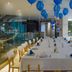 Inntu Hotel Medellín banquet table set with blue balloons and large windows overlooking greenery