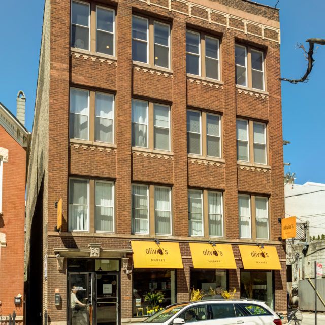 Urban Holiday Lofts in Chicago, brick exterior with yellow awnings and street-level storefronts