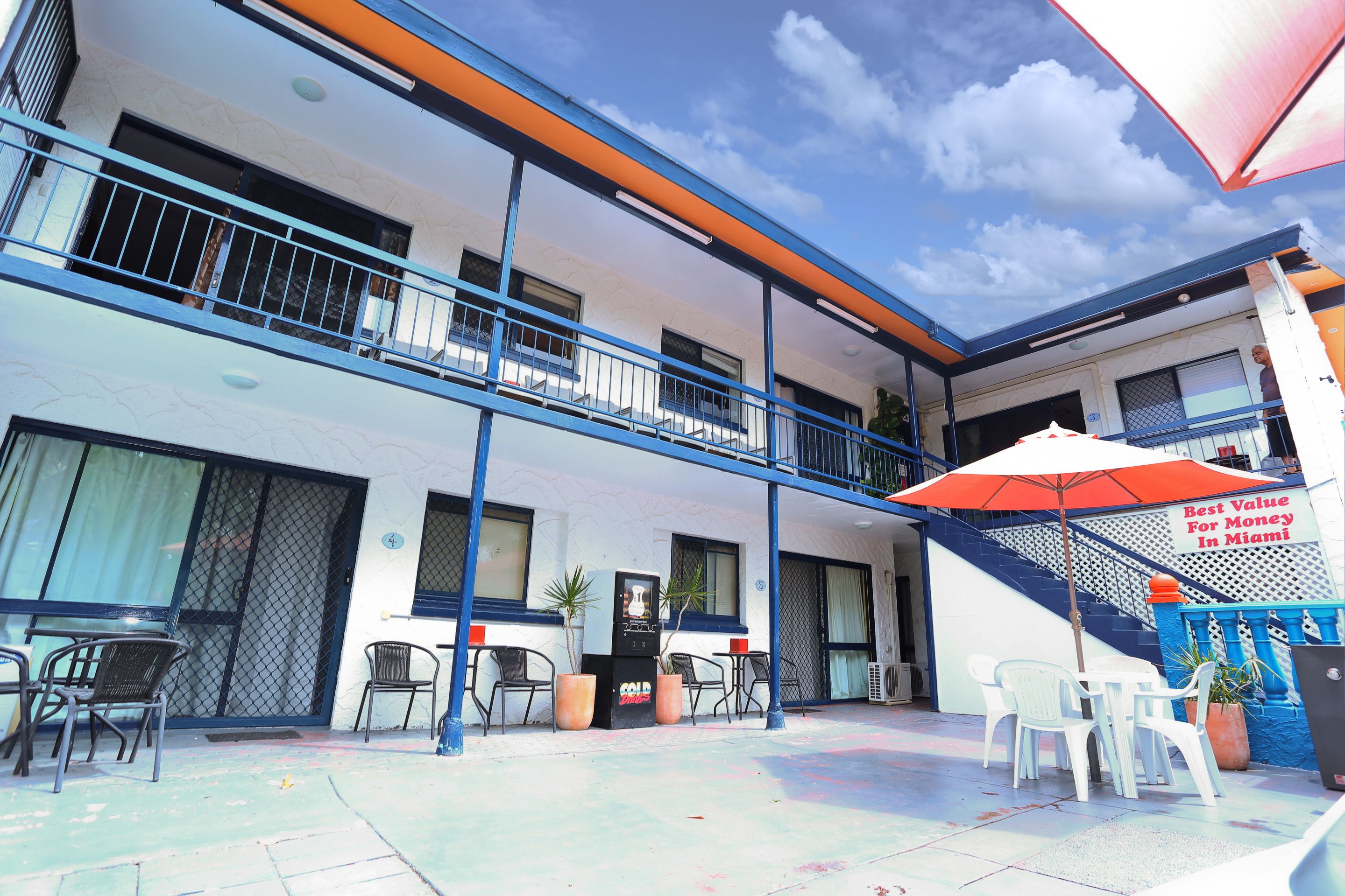 Miami Shore in Miami with outdoor courtyard, patio tables and chairs, and second-floor balconies