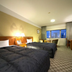 Toshi Center Hotel Tokyo room with two beds, desk, and city-view window