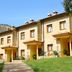 Residencial Los Robles in Arroyo Frio with row of tan rooms, private porches and grassy hillside setting