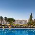 Penina Hotel & Golf Resort in Portimão with a large outdoor pool and palm-lined garden