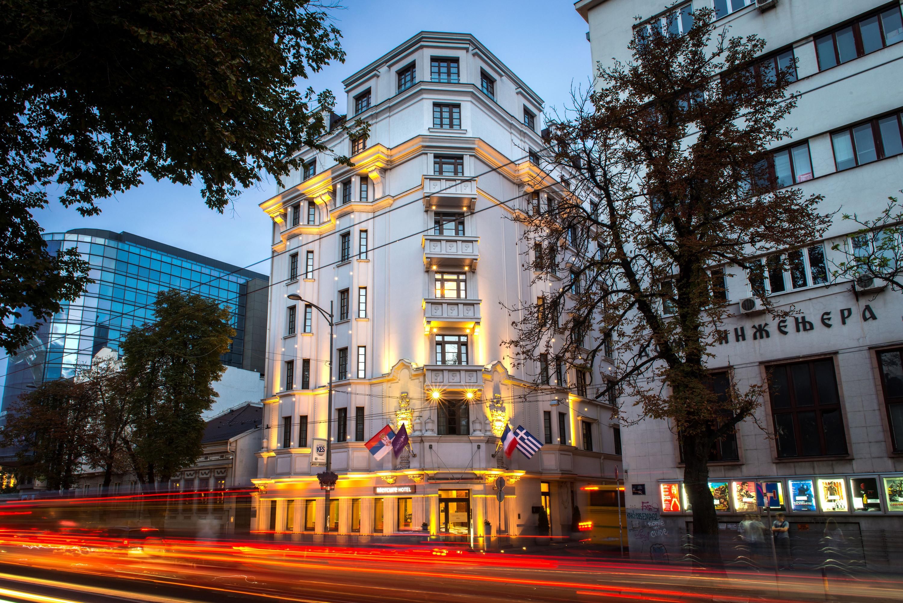 Mercure Belgrade Excelsior hotel exterior in Belgrade at dusk with illuminated facade and street traffic