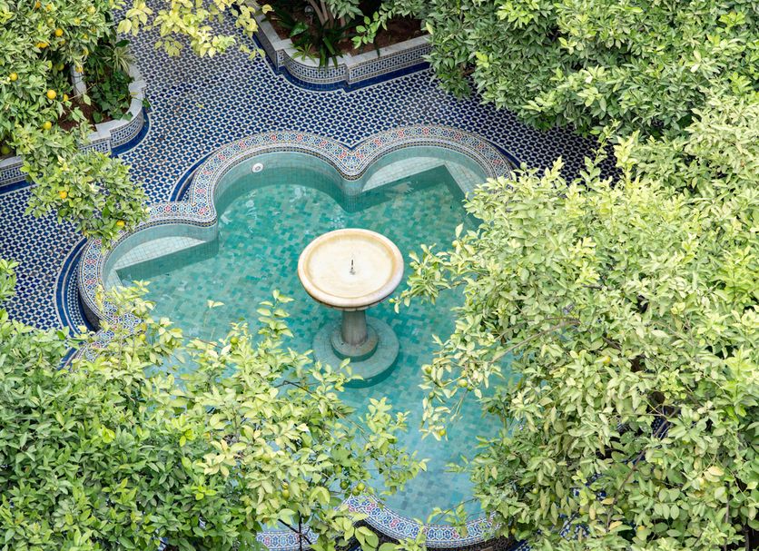 Palais Amani in Fez with a small heart-shaped courtyard pool surrounded by lush trees
