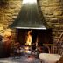 The Anchor Inn Bristol stone fireplace with burning fire, stacked logs, and cozy seating