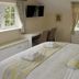 The Anchor Inn in Bristol guest room with king bed, desk, wall-mounted TV, and two windows