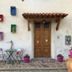 B&B Mangiafuoco in San Miniato, colorful wall shelves and a wooden door with potted flowers outside