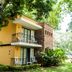 Hotel Villa Del Marques in Sopetrán with a two-story yellow building, balconies, and lush tropical trees