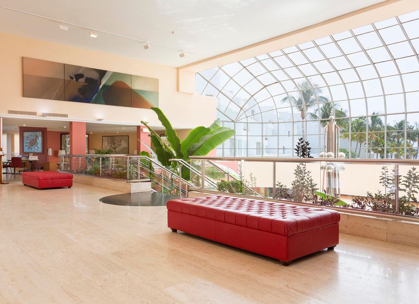 Hipotels La Geria in Puerto del Carmen lobby with red benches and large arched glass atrium