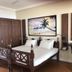 Sri Gemunu Beach Resort in Unawatuna, guest room with wooden bed, wardrobe, desk and beach wall art.