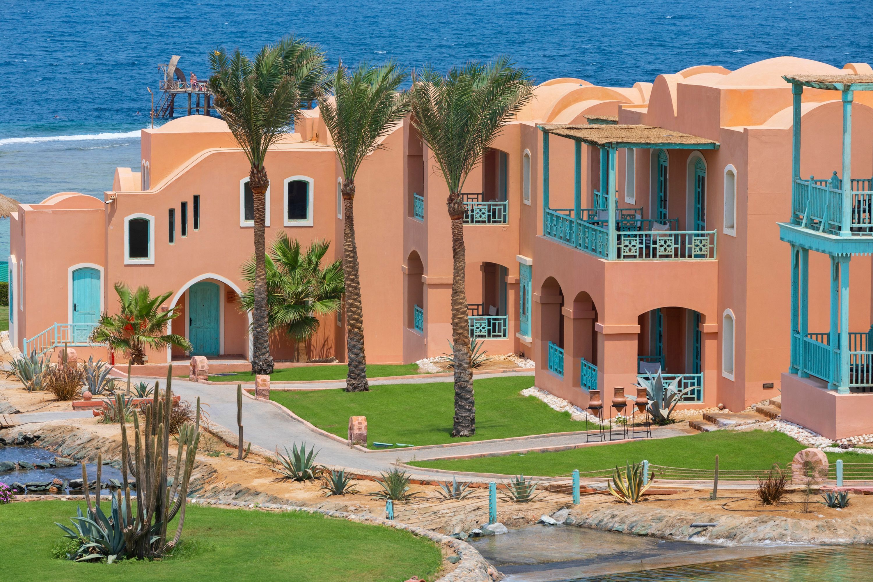 Swissotel Resort El Quseir in Al Quşayr with colorful seaside villas, palm trees, and ocean view