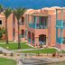 Swissotel Resort El Quseir in Al Quşayr with colorful seaside villas, palm trees, and ocean view