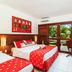 Hotel Village Porto De Galinhas room with two beds, desk, and balcony view of lush greenery in Porto de Galinhas