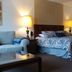 Wimberley Inn in Wimberley guest room with king bed, sofa, lamps, and wall art