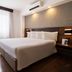 Deville Curitiba Batel guest room with king bed, wood nightstands, large window and wall-mounted air conditioner in Curitiba.
