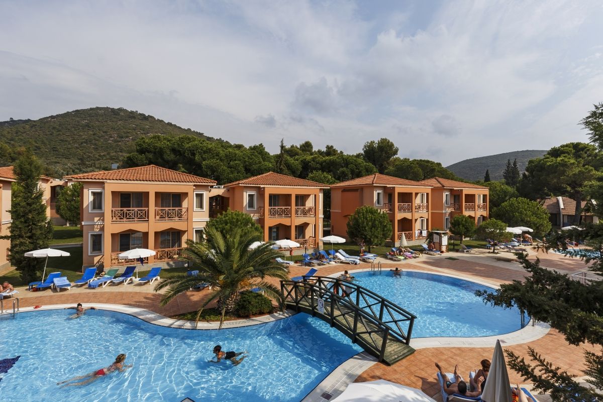Kustur Club Holiday Village in Kusadasi with a large outdoor pool, bridge, and sun loungers