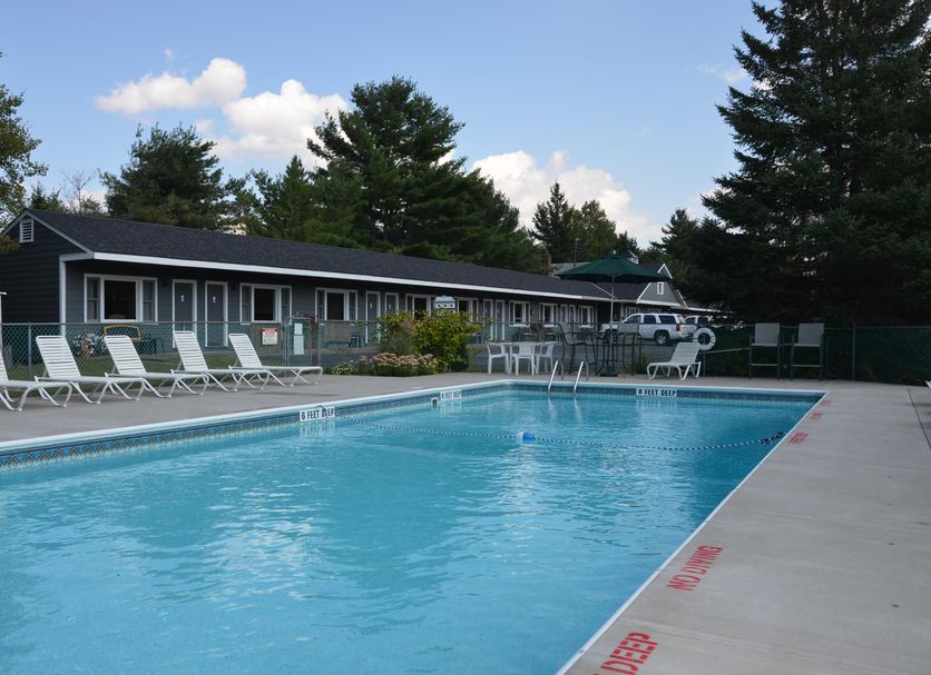 Grand View Motel in Wilmington with an outdoor pool, lounge chairs, and trees beside the motel