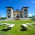 Hotel Villa La Bollina in Serravalle Scrivia with a grand villa façade and lounge chairs on a lawn