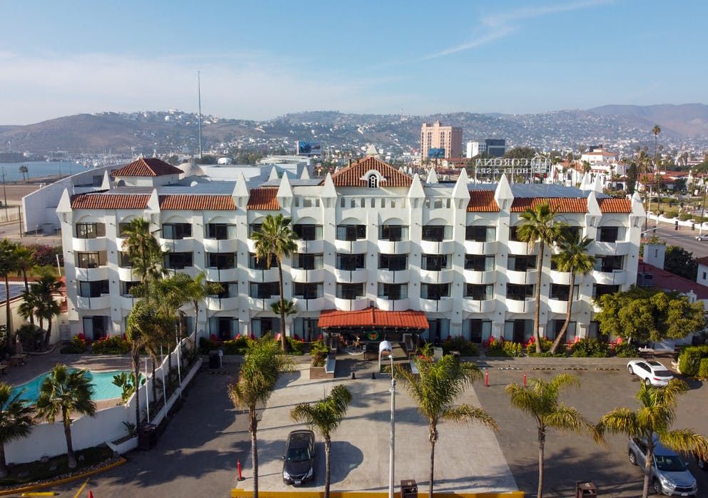 Corona Hotel & Spa in Ensenada with palm trees, ocean view, and a curved outdoor pool