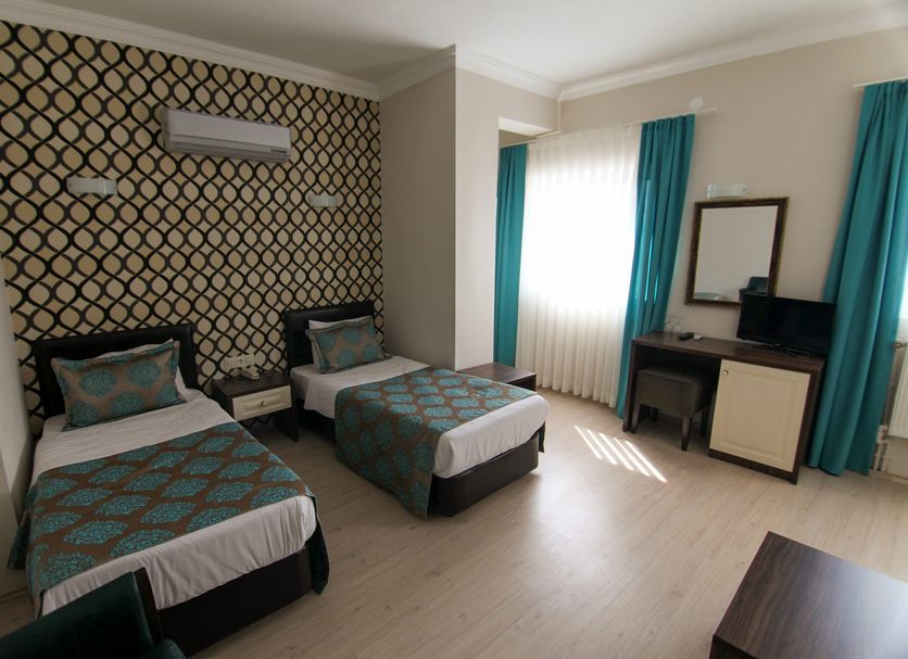 Sagiroglu Hotel in Trabzon guest room with two twin beds, desk, mirror, and teal curtains