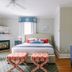 The Bayberry Inn in Newport guest room with fireplace, bed, patterned ottomans and blue dresser