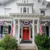 The Bayberry Inn in Newport, white Victorian facade with red front door and American flags