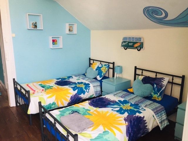 The Paintshop Hostel in Figueira da Foz: colorful twin room with blue floral bedding and wall art