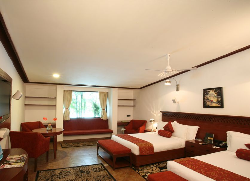 Lagoon Bay-Leonia Holistic Destination room in Shamirpet with two beds, red seating, and a window bench