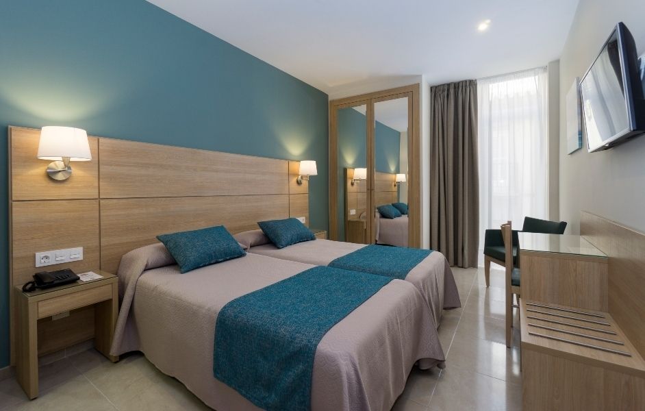Hotel Sur Málaga in Málaga guest room with twin beds, mirrored wardrobe, desk, and wall-mounted TV