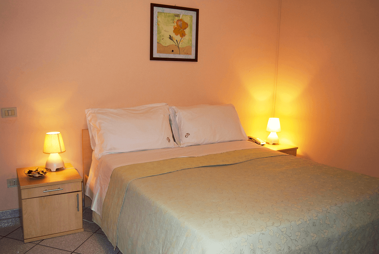 Roman Country Residence S.R.L. bedroom in Rome with double bed, bedside lamps and framed wall art