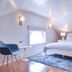 Hotel Pippa Nantucket attic bedroom with vaulted ceiling, king bed, blue chair and bedside lamps