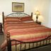 Black Forest Bed & Breakfast in Helen: cozy guest room with wrought-iron bed, striped bedding, and bedside lamps