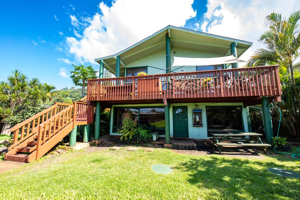 Backpackers Vacation Inn and Plantation Village in Haleiwa: two-story tropical lodge with wooden deck and stairs